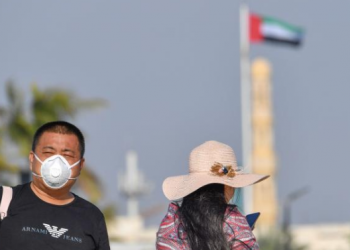 سائح يرتدي قناعا للوجه في دبي، بالامارات العربية