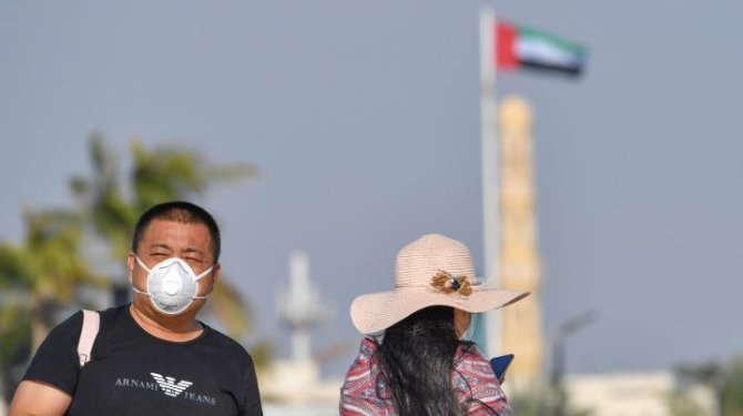 سائح يرتدي قناعا للوجه في دبي، بالامارات العربية