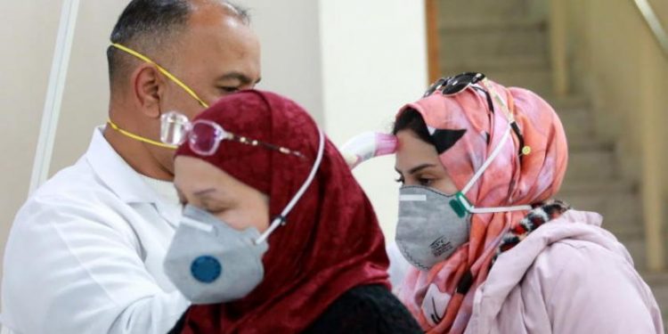 طبيب يفحص الركاب القادمين من إيران في مطار بغداد الدولي