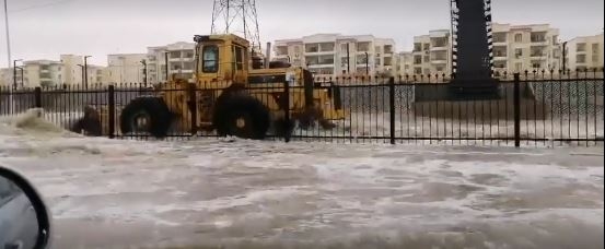 بالفيديو.. اللوادر تسبح في شوارع 6 أكتوبر بسبب الأمطار الغزيرة 1