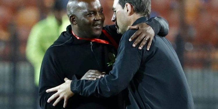 Ahly's Swiss manager Rene Weiler (R) is embraced by Mamelodi's South African manager Pitso Mosimane (L) during the first leg of the CAF Champions League Quarter-final football match between Egypt's Al-Ahly and South Africa's Mamelodi Sundowns at al-Ahly Stadium in the capital Cairo on February 29, 2020. (Photo by Khaled DESOUKI / AFP)