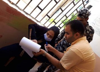 مسئول إحدى اللجان بالإسكندرية يخرج بأوراق الاقتراع لمساعدة مسنة على التصويت 5