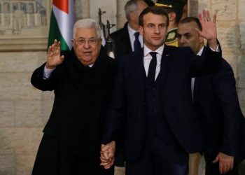 French President Emmanuel Macron (R) and Palestinian President Mahmoud Abbas wave to the press during their meeting in the West Bank City of Ramallah on January 22, 2020. (Photo by Ludovic MARIN / AFP)