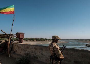 TOPSHOT - A member of the Amhara Special Forces watches on at the border crossing with Eritrea where an Imperial Ethiopian flag waves, in Humera, Ethiopia, on November 22, 2020. - Prime Minister Abiy Ahmed, last year's Nobel Peace Prize winner, announced military operations in Tigray on November 4, 2020, saying they came in response to attacks on federal army camps by the party, the Tigray People's Liberation Front (TPLF). Hundreds have died in nearly three weeks of hostilities that analysts worry could draw in the broader Horn of Africa region, though Abiy has kept a lid on the details, cutting phone and internet connections in Tigray and restricting reporting. (Photo by EDUARDO SOTERAS / AFP)
