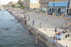 صور.. أهالى الأقصر يهربون من الحر بالسباحة فى النيل في نهار رمضان 11