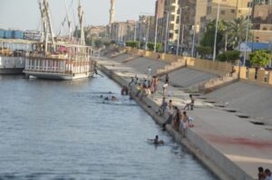 صور.. أهالى الأقصر يهربون من الحر بالسباحة فى النيل في نهار رمضان 6