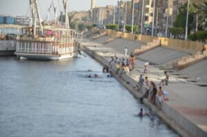 صور.. أهالى الأقصر يهربون من الحر بالسباحة فى النيل في نهار رمضان 3