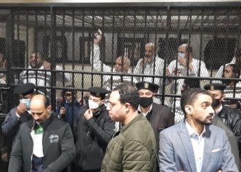 دفاع علاء حسانين يقدم صورة فوتوغرافية للمحكمة أثناء وجوده بمؤتمر بقرية دلجا قبل ضبطه بساعات
