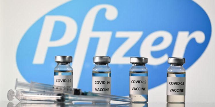An illustration picture shows vials with Covid-19 Vaccine stickers attached and syringes with the logo of US pharmaceutical company Pfizer, on November 17, 2020. (Photo by JUSTIN TALLIS / AFP)